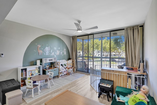 playroom featuring ceiling fan, floor to ceiling windows, and hardwood / wood-style floors