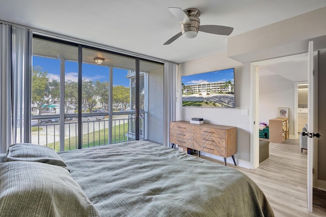 bedroom with access to exterior, floor to ceiling windows, ceiling fan, and light wood-type flooring