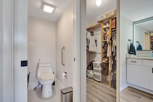 bathroom with hardwood / wood-style flooring, vanity, and toilet