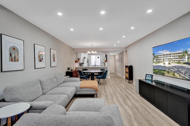 living room featuring an inviting chandelier and light hardwood / wood-style flooring