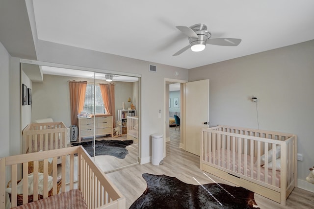 bedroom featuring wood-type flooring, ceiling fan, and a closet