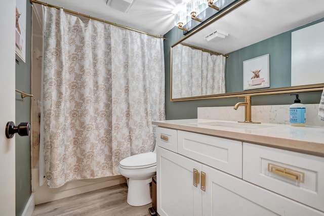 full bathroom featuring vanity, hardwood / wood-style floors, shower / tub combo with curtain, and toilet