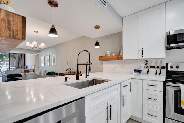 kitchen with light stone countertops, appliances with stainless steel finishes, pendant lighting, and white cabinets