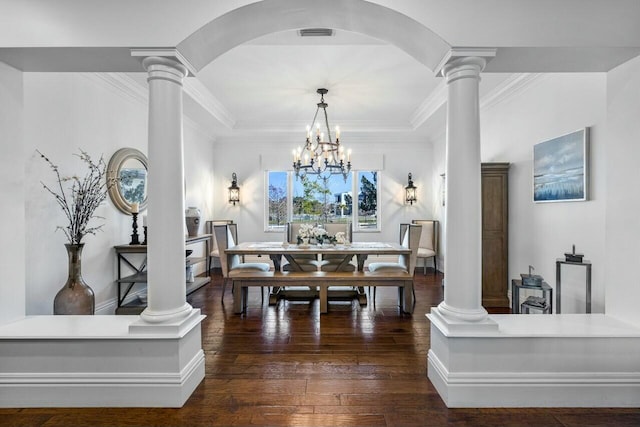 dining room with decorative columns, ornamental molding, an inviting chandelier, and dark hardwood / wood-style flooring