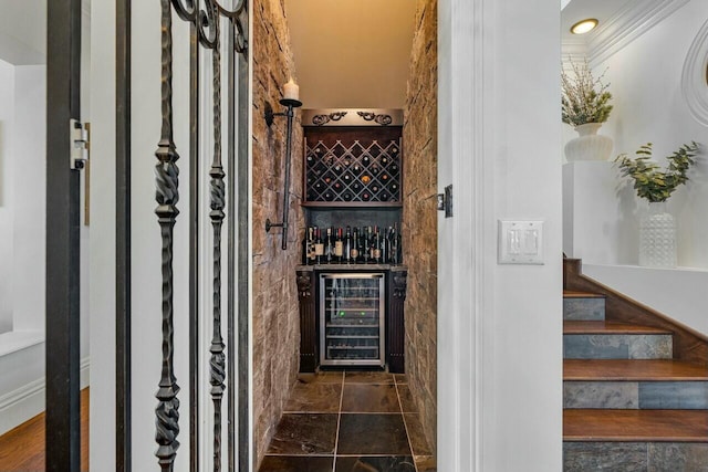 wine cellar featuring ornamental molding and beverage cooler