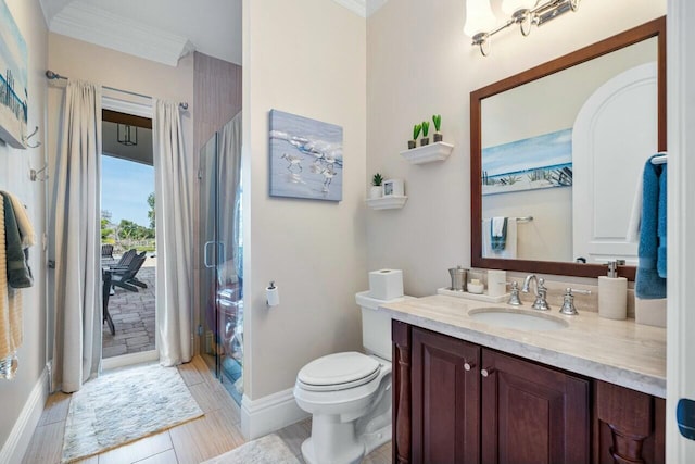 bathroom featuring ornamental molding, vanity, toilet, and a shower