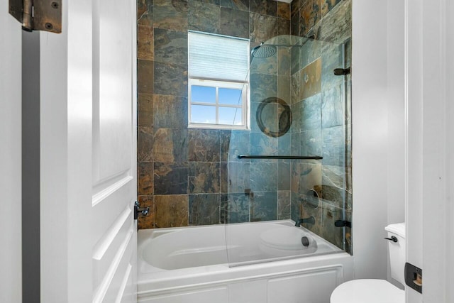 bathroom with toilet and tiled shower / bath