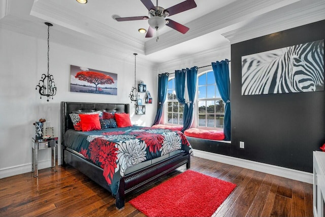 bedroom featuring ornamental molding, dark hardwood / wood-style floors, ceiling fan, and a tray ceiling