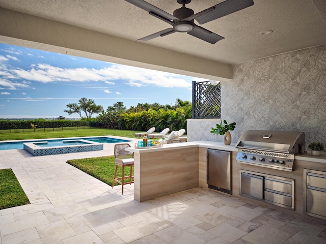 view of patio featuring area for grilling, an outdoor bar, ceiling fan, and a pool with hot tub