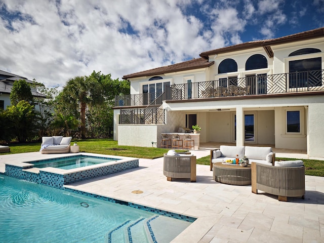 rear view of property with a balcony, a patio area, stucco siding, and an outdoor living space