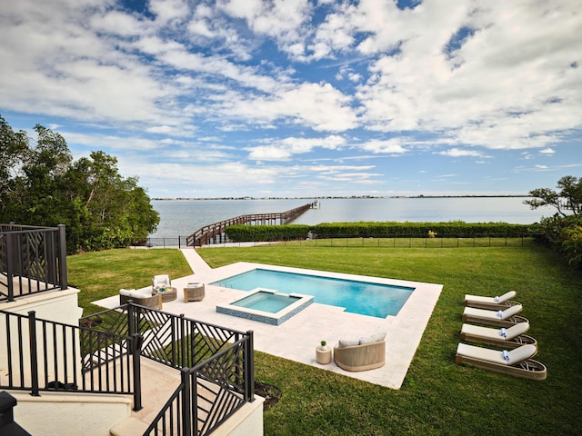 view of swimming pool featuring a water view, an in ground hot tub, and a lawn