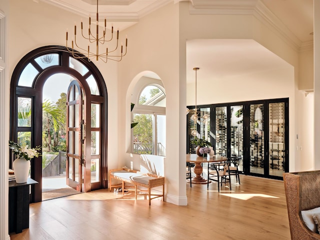 doorway featuring french doors, an inviting chandelier, wood finished floors, and a high ceiling