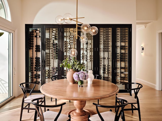 wine area with an inviting chandelier and light hardwood / wood-style flooring