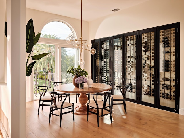 dining room featuring a notable chandelier, visible vents, and wood finished floors