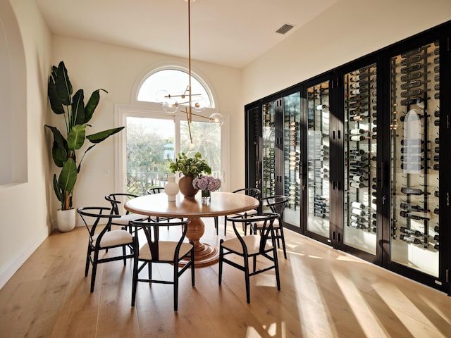 dining space with an inviting chandelier and light hardwood / wood-style floors