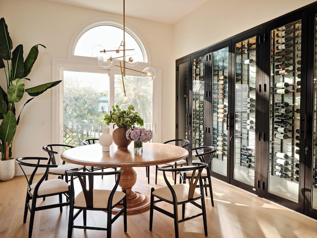 dining space featuring light wood-type flooring and a notable chandelier