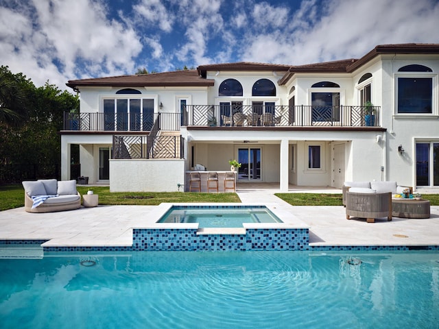 back of property with a patio area, outdoor lounge area, and a balcony