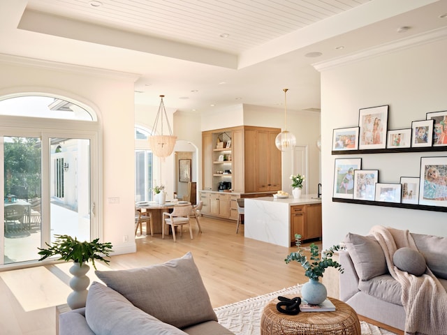 living room with ornamental molding, light hardwood / wood-style floors, a raised ceiling, and wooden ceiling