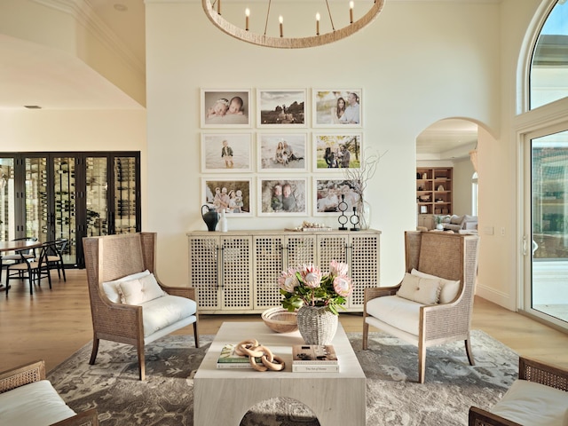 sitting room with a notable chandelier, wood-type flooring, and a high ceiling