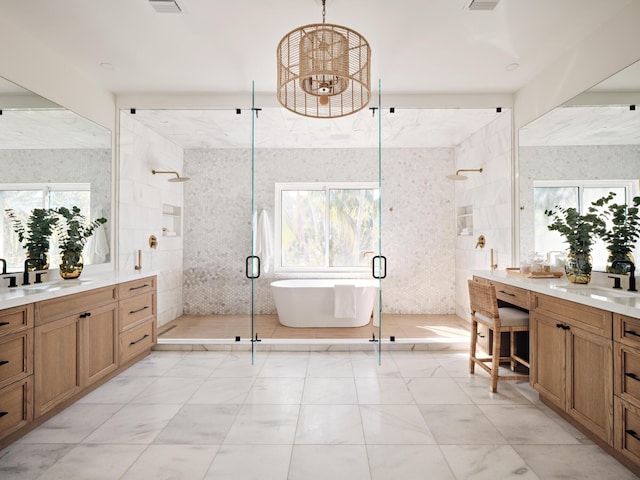 bathroom with a sink, tile walls, a shower stall, and a healthy amount of sunlight