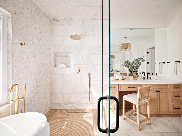 bathroom featuring a freestanding bath, vanity, and a tile shower