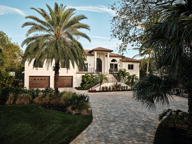 mediterranean / spanish house with a garage and a front yard