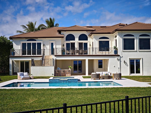 back of house with an in ground hot tub, a balcony, an outdoor living space, and a patio area