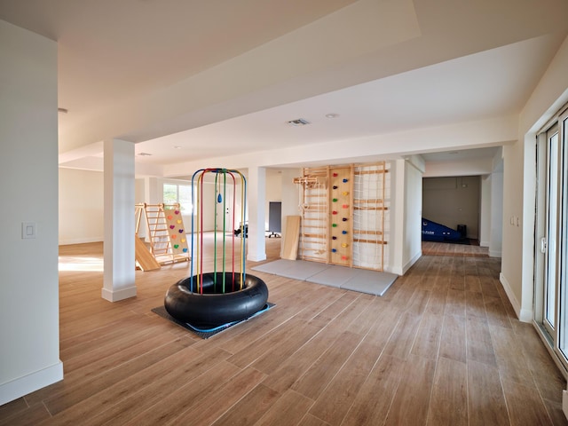 exercise room featuring baseboards and wood finished floors