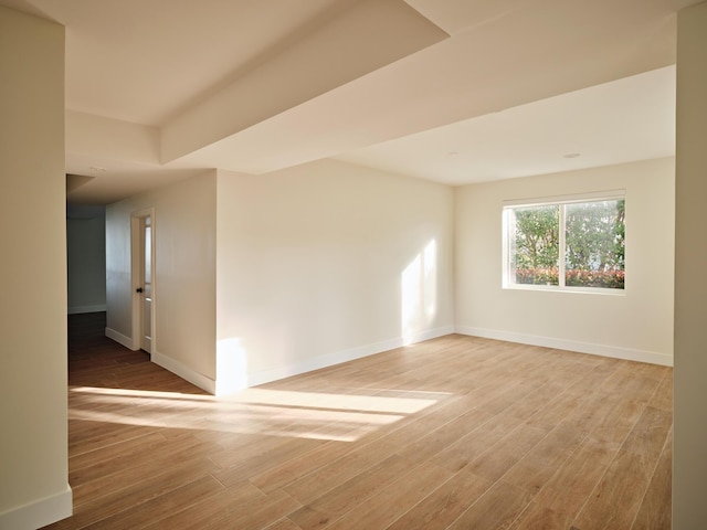 spare room featuring baseboards and wood finished floors