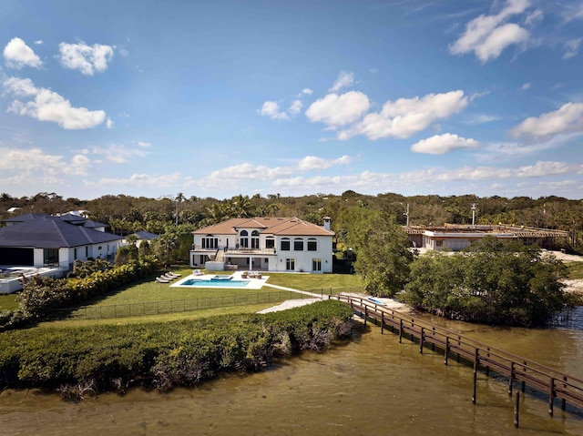 rear view of property with a yard, a balcony, and a water view