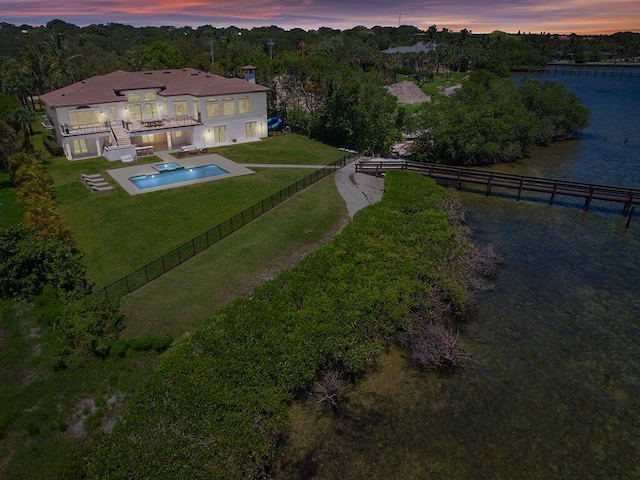 aerial view at dusk featuring a water view