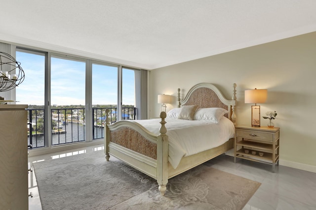 bedroom featuring crown molding, expansive windows, a chandelier, and a water view