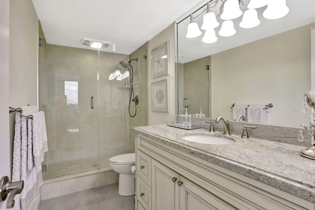 bathroom with an enclosed shower, vanity, tile patterned floors, and toilet