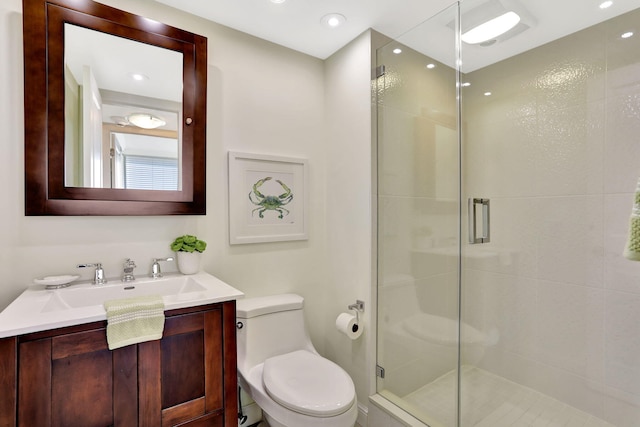 bathroom featuring an enclosed shower, vanity, and toilet