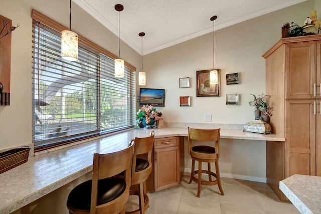 kitchen with a textured ceiling, ornamental molding, light tile patterned floors, and built in study area