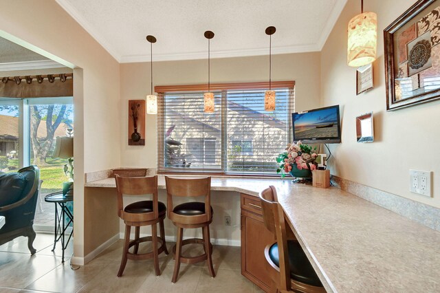 kitchen with hanging light fixtures, light countertops, and crown molding