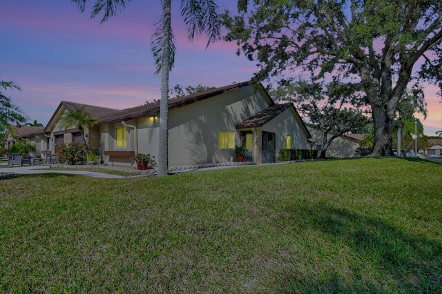 ranch-style home with a garage and a front lawn