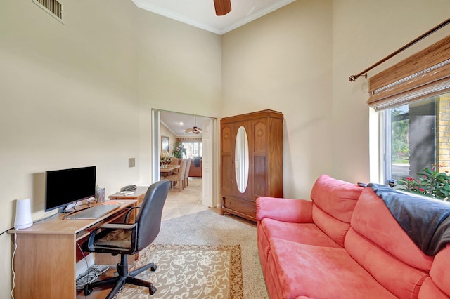 office area featuring crown molding, visible vents, a high ceiling, ceiling fan, and plenty of natural light