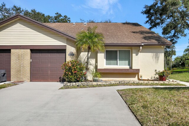 ranch-style house featuring a garage and a front lawn