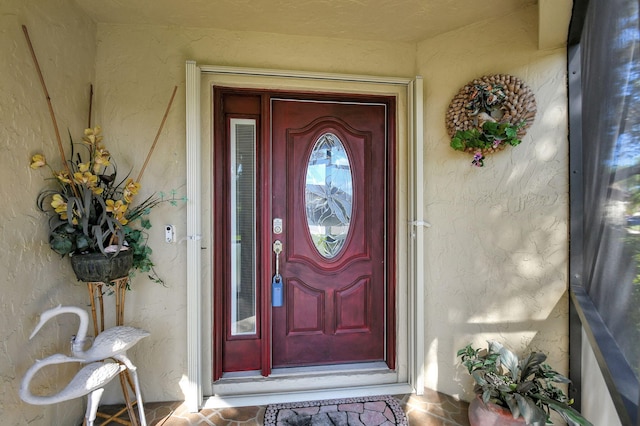 view of exterior entry featuring stucco siding