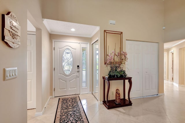 foyer with recessed lighting, baseboards, ornamental molding, and light tile patterned flooring