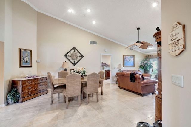 dining area with light tile patterned floors, high vaulted ceiling, visible vents, a ceiling fan, and ornamental molding