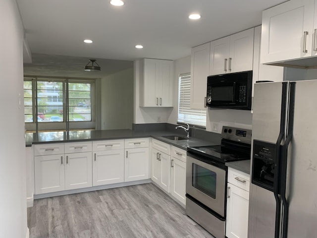 kitchen with sink, kitchen peninsula, stainless steel appliances, light hardwood / wood-style floors, and white cabinets