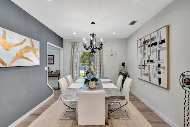 dining space featuring a notable chandelier and light hardwood / wood-style floors