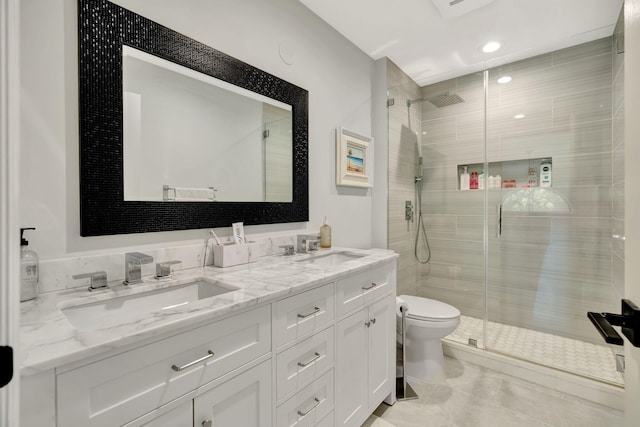 bathroom featuring a shower with door, vanity, and toilet