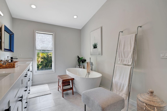 bathroom featuring vanity, tile patterned floors, and a tub