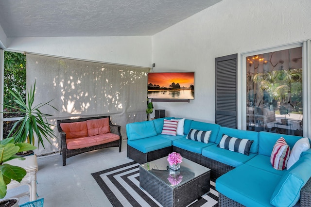 living room with lofted ceiling, a textured ceiling, and concrete floors