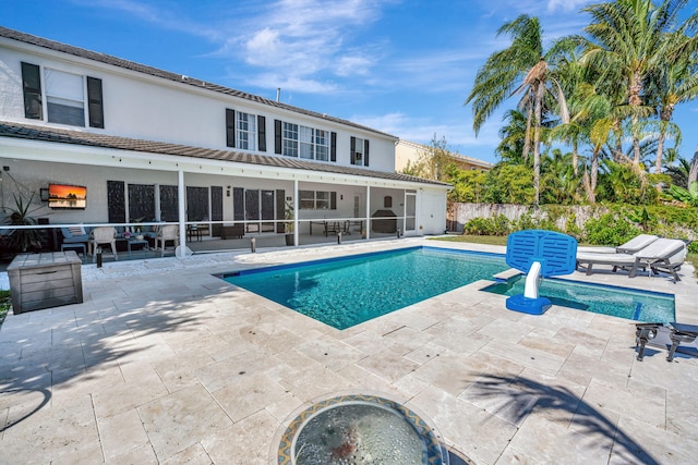 view of pool featuring a jacuzzi, a patio area, and a sunroom