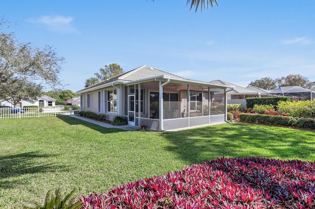 view of front of home with a sunroom and a front lawn