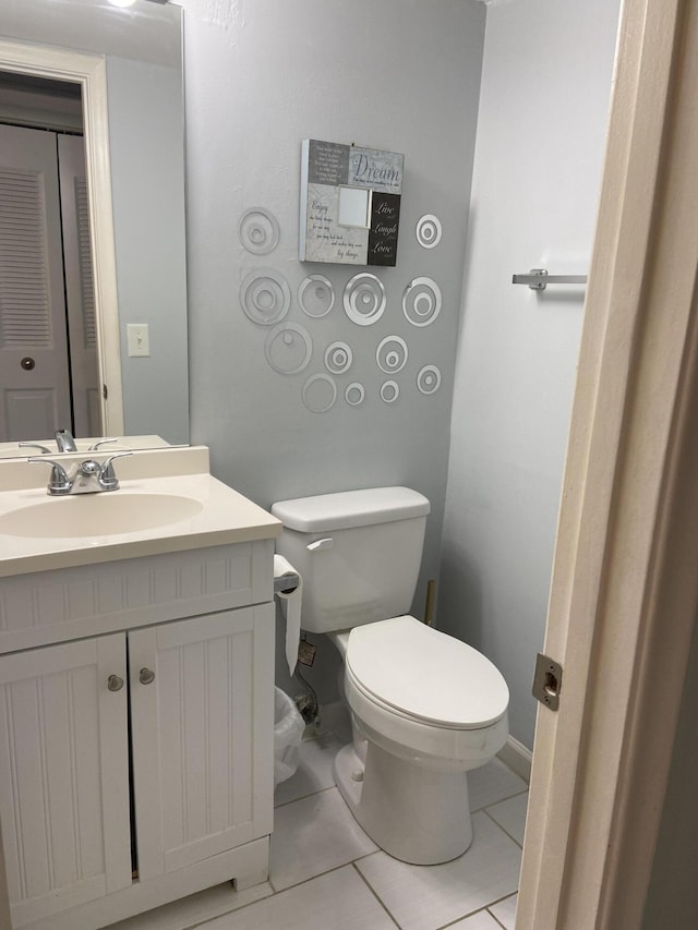 bathroom featuring vanity, tile patterned floors, and toilet